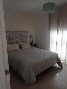 a bedroom with a large bed and a window at Cañete 4 in Las Lagunas