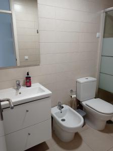 a white bathroom with a toilet and a sink at Cañete 4 in La Laguna