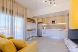 a living room with a yellow couch and a kitchen at De Mar Village Apartments, Agios Nikolaos in Agios Nikolaos