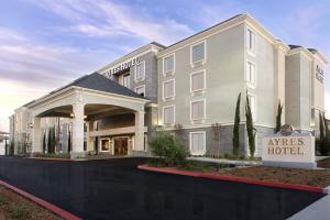 a hotel building with a sign in front of it at Ayres Hotel Huntington Beach/Fountain Valley in Fountain Valley