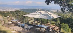 einen Pavillon mit Stühlen und einem Sonnenschirm auf einer Terrasse in der Unterkunft Gîte Les Cadichons de la Grange in Saint-Péray