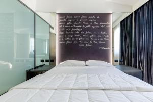 Un dormitorio con una cama y una pared con escritura. en Motel Rona, en Caponago