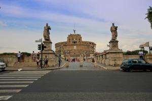 a building with two statues on the side of a street at Castel Sant Angelo Luxury Rooms and Tour in Rome