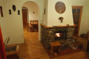 a living room with a stone fireplace and a table at Cottage House in Stožec
