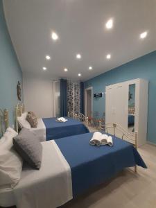 two beds in a room with blue and white at Elipa in Mandra Capreria