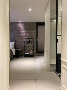 a bedroom with a bed and a brick wall at Hotel Gaden in Suwon