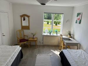 a bedroom with a bed and a desk and a window at Annexet Kilafors in Kilafors