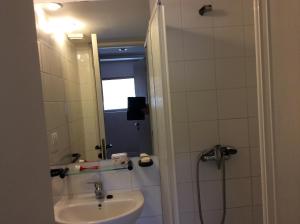 un bagno con lavandino e doccia con specchio di San Alfonso Apartment ad Algarrobo