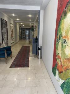 einen Flur mit einem großen Gemälde an der Wand in der Unterkunft Hotel Bojatours in Podgorica