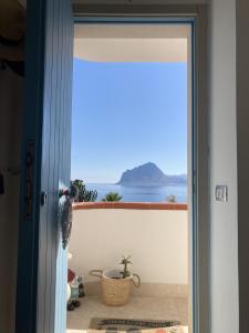 una puerta a un balcón con vistas al océano en Residence Tamarea, en Valderice