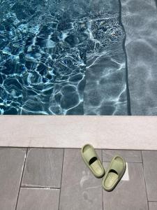un par de chanclas sentadas junto a una piscina en Residence Tamarea, en Valderice
