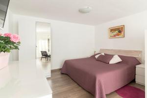 ein weißes Schlafzimmer mit einem Bett und einem Spiegel in der Unterkunft Apartments Fine Stay Slovenia in Žirovnica