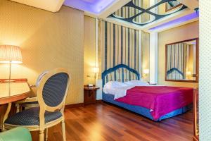 利米托迪皮奥尔泰洛Hotel Motel Miami的一间卧室，里面有一张床、一张桌子和一把椅子