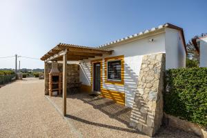 a small house with a yellow and white at Monte do Tanoeiro - Casa Nova in Rogil