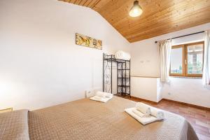 a bedroom with a large bed with two white chairs at Monte do Tanoeiro - Casa Nova in Rogil