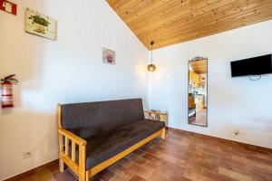 a couch in the corner of a room with a tv at Monte do Tanoeiro - Casa Nova in Rogil