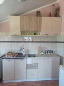 a kitchen with white cabinets and a sink at Apartman Balsa in Kotor