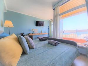 a bedroom with a blue bed with pillows on it at Tarik Beach Apartment in Portimão
