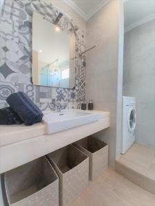 a bathroom with a sink and a mirror at Tarik Beach Apartment in Portimão
