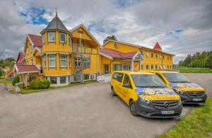 two cars parked in front of a yellow house at Gardermoen Hotel Bed & Breakfast in Gardermoen