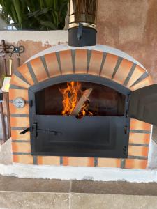 a pizza oven with a fire inside of it at Charmant rez de villa en provence in Le Tignet