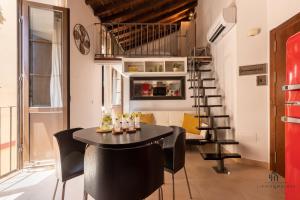 um quarto com uma mesa e cadeiras e uma escada em espiral em Living4Malaga La Dolce Vita Duplex em Málaga