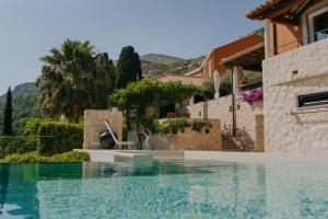 a swimming pool in front of a house at NINON Dubrovnik - Adults Only in Brsečine