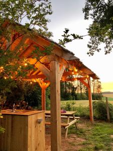 gazebo in legno con tavolo da picnic in un campo di Cowcooning / Family tents a Huldenberg Altre 6 foto