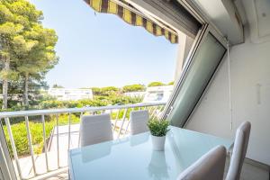 d'un balcon avec une table et des chaises et une vue sur l'océan. dans l'établissement LE WHITE - CLIM PARKING WIFI 5min PLAGE NEUF 6MAX -TOP PROS SERVICESConciergerie, à La Grande Motte