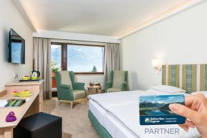 a person taking a picture of a hotel room at ALPIN- Das Sporthotel - SKI IN SKI OUT cityXpress, SUMMERCARD INCLUDED in Zell am See