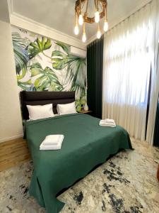 Style Home Buzovna في باكو: غرفة نوم بسرير اخضر مع بطانية خضراء