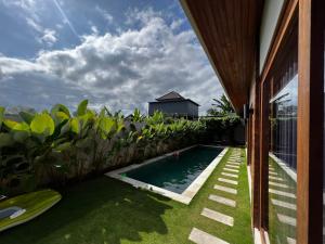 a swimming pool in the yard of a house at Villa Sandhyā Tabanan in Tabanan