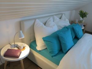 a bed with blue pillows and a table with a book at Allgäu Spirit in Immenstadt im Allgäu