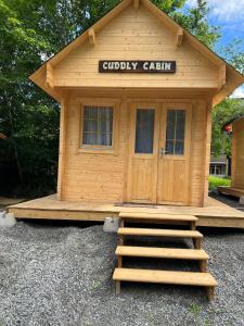 drewniany domek ze schodami przed nim w obiekcie Cuddly Cabin At The Lake On Muskoka Shores w mieście Otter Lake