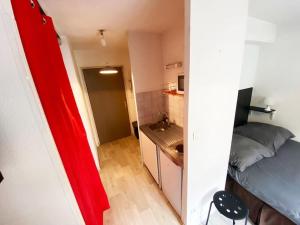 a small room with a bed and a kitchen at Studio le République in Dijon