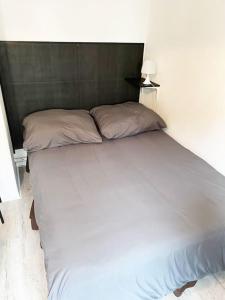 - un grand lit blanc avec deux oreillers dans l'établissement Studio le République, à Dijon