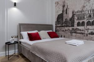 um quarto com uma cama grande e almofadas vermelhas em Apartament w centrum Krakowa 109 em Cracóvia