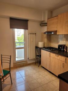 een keuken met een fornuis en een raam erin bij Peaceful Loft in Boekarest +3 foto's
