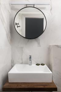 a bathroom with a white sink and a mirror at The City Gem Urban Apt. in Rhodes Town