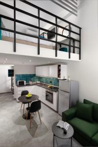 a living room with a green couch and a kitchen at The City Gem Urban Apt. in Rhodes Town