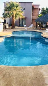 uma grande piscina com água azul em frente a um edifício em Relax in the Charming Casita Mezquites #5 em Puerto Peñasco