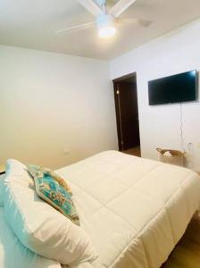 a bedroom with a white bed with a pillow on it at Relax in the Charming Casita Mezquites #5 in Puerto Peñasco