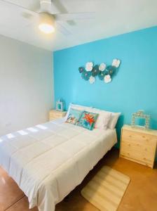 a bedroom with a large bed with a blue wall at Relax in the Charming Casita Mezquites #5 in Puerto Peñasco
