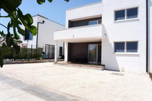 a white house with a courtyard in front of it at Station 22 - Brand new apartment with a terrace and private parking in Vir