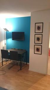 ein Esszimmer mit einem Tisch und einem TV an der Wand in der Unterkunft Apartment Blue Regensburg in Regensburg