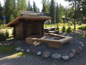a picnic shelter with a table and a fire pit at Villa Tumppu in Jämsä