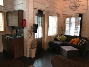 a living room with a couch and a kitchen at Villa Tumppu in Jämsä