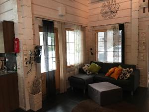 a living room with a couch and some windows at Villa Tumppu in Jämsä +9 photos