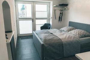 une chambre avec un lit, un canapé et des fenêtres dans l'établissement Apartment Haus Inge, à Dürrröhrsdorf