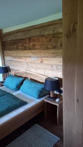 um quarto com 2 camas e uma parede de madeira em Huis am Berg em Immenstadt im Allgäu